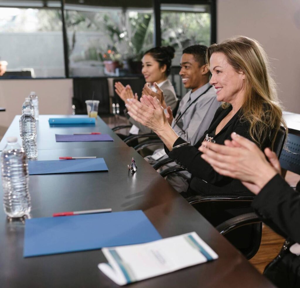 Business people applauding at a meeting.